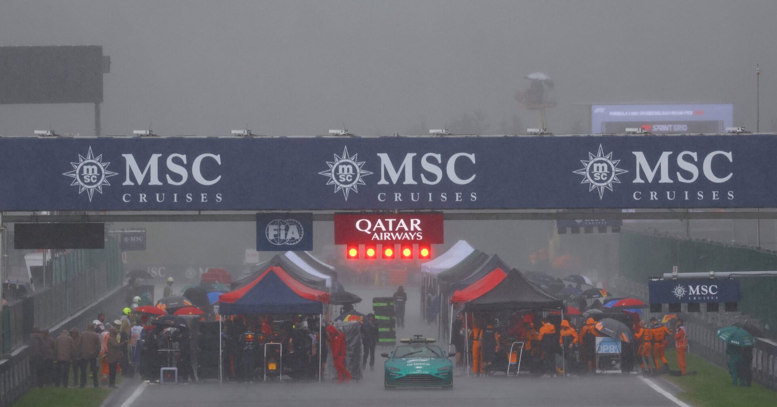 SPA, BELGIUM - JULY 29: Max Verstappen of the Netherlands driving the (1) Oracle Red Bull Racing RB19 and Oscar Piastri of Australian GP and McLaren line up as teams shelter from the rain on the grid during the Sprint ahead of the F1 Grand Prix of Belgium at Circuit de Spa-Francorchamps on July 29, 2023 in Spa, Belgium. (Photo by Mark Thompson/Getty Images) // Getty Images / Red Bull Content Pool //