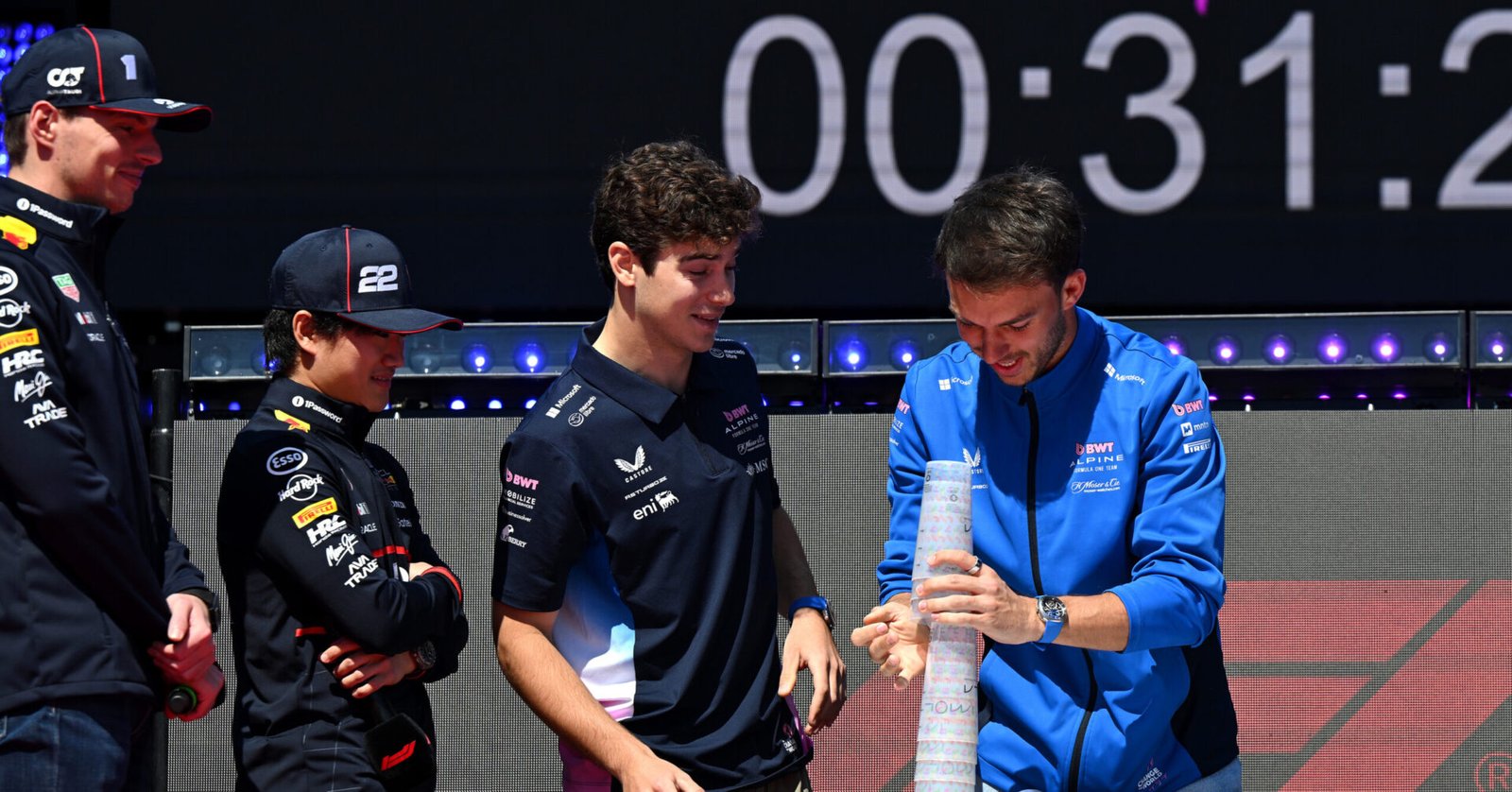 IMOLA, ITALY - MAY 17: Max Verstappen of the Netherlands and Oracle Red Bull Racing, Yuki Tsunoda of Japan and Oracle Red Bull Racing and Franco Colapinto of Argentina and Alpine F1 look on as Pierre Gasly of France and Alpine F1 stacks cups on the fan stage prior to final practice ahead of the F1 Grand Prix of Emilia-Romagna at Autodromo Internazionale Enzo e Dino Ferrari on May 17, 2025 in Imola, Italy. (Photo by Sam Bagnall/Sutton Images) // Getty Images / Red Bull Content Pool // SI202505170080 // Usage for editorial use only //