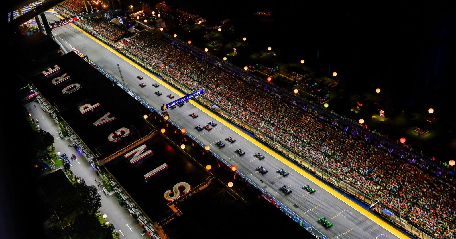 SINGAPORE, SINGAPORE - SEPTEMBER 22: Lando Norris of Great Britain driving the (4) McLaren MCL38 Mercedes leads Max Verstappen of the Netherlands driving the (1) Oracle Red Bull Racing RB20 and the rest of the field into turn one at the start during the F1 Grand Prix of Singapore at Marina Bay Street Circuit on September 22, 2024 in Singapore, Singapore. (Photo by Joe Portlock/Getty Images) // Getty Images / Red Bull Content Pool // SI202409220309 // Usage for editorial use only //