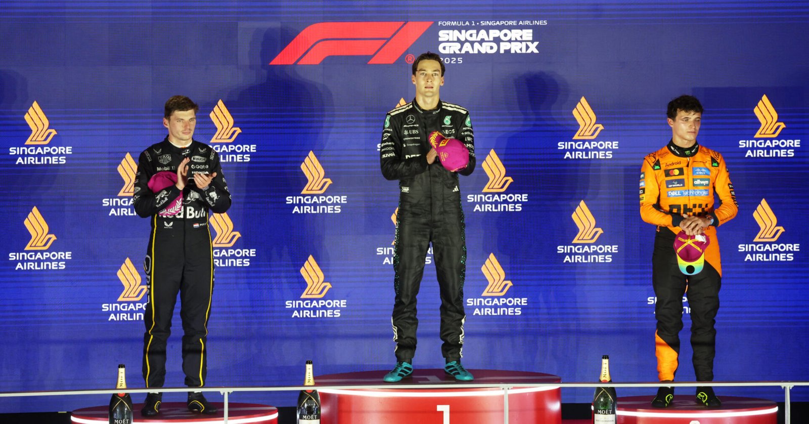 SINGAPORE, SINGAPORE - OCTOBER 05: Race winner George Russell of Great Britain and Mercedes AMG Petronas F1 Team Second placed Max Verstappen of the Netherlands and Oracle Red Bull Racing and Third placed Lando Norris of Great Britain and McLaren on the podium during the F1 Grand Prix of Singapore at Marina Bay Street Circuit on October 05, 2025 in Singapore, Singapore. (Photo by Glenn Dunbar/LAT Images) // Getty Images / Red Bull Content Pool // SI202510050918 // Usage for editorial use only //